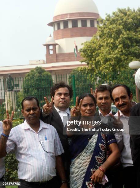 Nirbhaya's parents show victory sign after the Supreme Court's verdict in New Delhi.