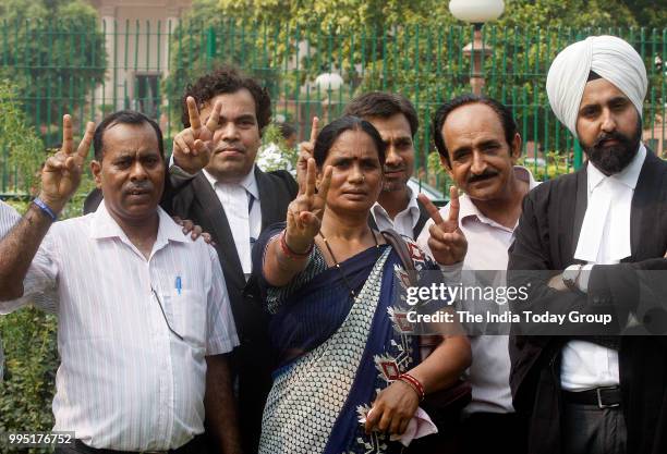 Nirbhaya's parents show victory sign after the Supreme Court's verdict in New Delhi.