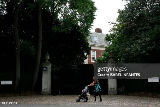 Woman pushes a pram past the entrance of Winfield House in Regent's Park, the US Ambassador's London residence, on July 10, 2018 ahead of the visit...