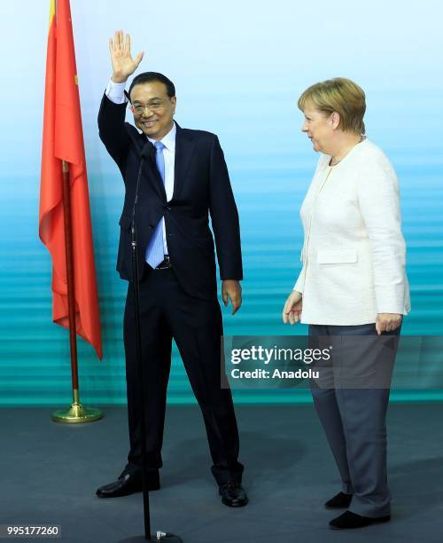 German Chancellor Angela Merkel and Chinese Premier Li Keqiang hold a press conference pose for a photo with officials as they attend a presentation...