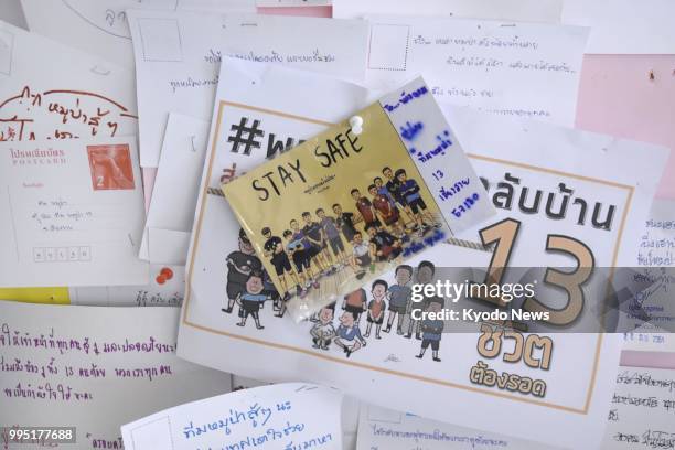 Photo taken on July 10 shows message cards for the 12 boys and their soccer coach displayed near the Tham Luang Nang Non cave in Thailand's northern...