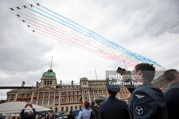 Members of the Royal Air Force watch the Red Arrows flypast over Horse Guards Parade during RAF 100 celebrations on July 10, 2018 in London, England....