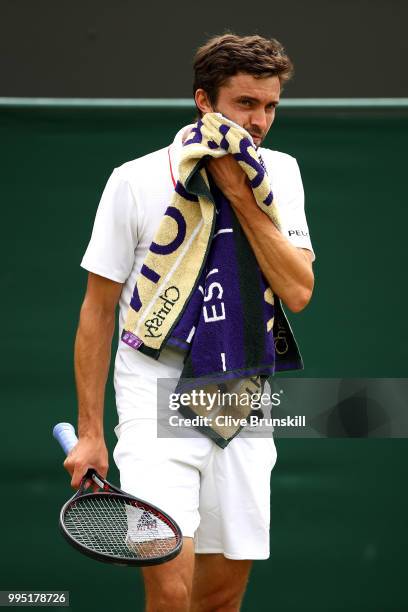 Gilles Simon of France towels down against Juan Martin Del Potro of Argentina during their Men's Singles fourth round match on day eight of the...