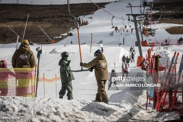 Skier is helped by an attendant at the ski-lift at Afriski in the Maluti Mountains of the Southern African Kingdom of Lesotho, on July 10, 2018. -...