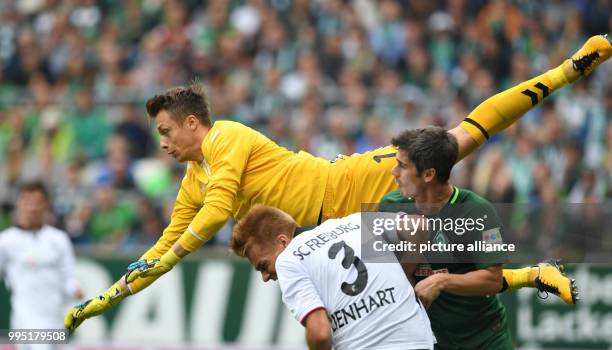 Bremen's goalkeeper Fin Bartels attempts to beat Freiburg's Alexander Schwolow to the ball during the German Bundesliga match between Werder Bremen...