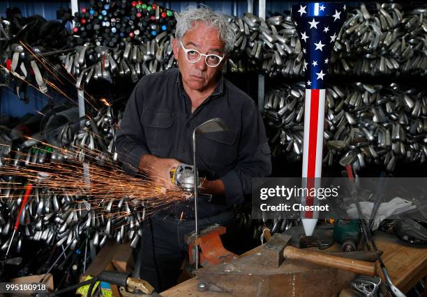 French creator, sculptor and artist, Hubert Prive poses in his workshop with his creations entitled "Gravitation" and "2018, with the stars"...