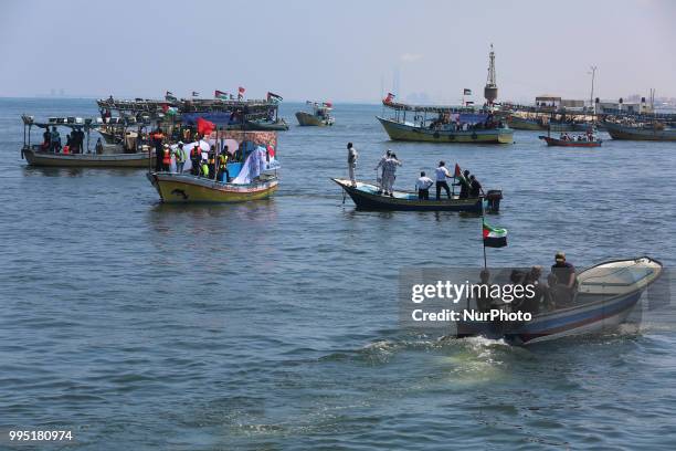 Palestinian activists and fishermen take boats out to sea from the Gaza City harbour on July 10, 2018 protesting against Israel's naval blockade on...