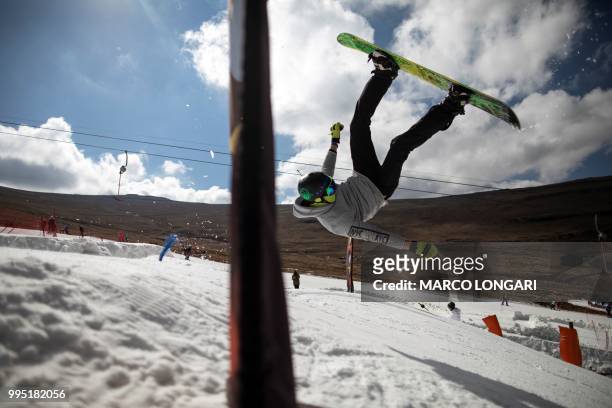 Snowboarder performs a back flip at Afriski in the Maluti Mountains of the Southern African Kingdom of Lesotho, on July 10, 2018. - Nestled high in...