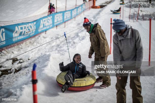 Attendants share a light moment at one of the attractions at Afriski in the Maluti Mountains of the Southern African Kingdom of Lesotho, on July 10,...