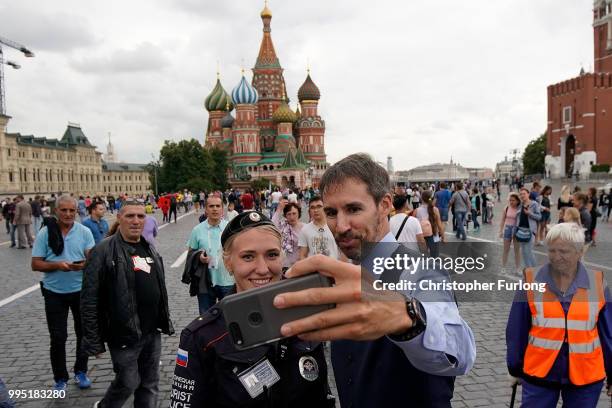 Gareth Southgate lookalike Neil Rowe poses for a selfie with a tourist police officer as he causes a stir as football fans, TV crews and tourists...