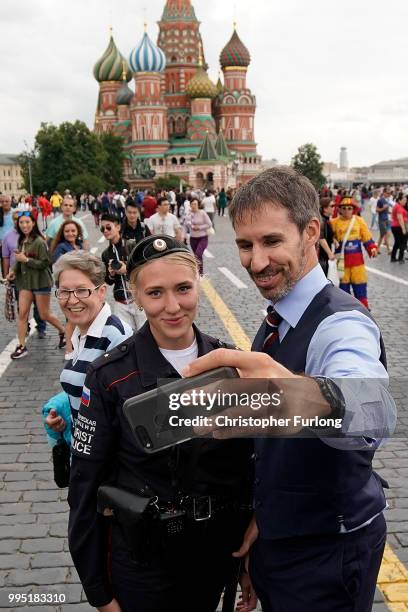 Gareth Southgate lookalike Neil Rowe poses for a selfie with a tourist police officer as he causes a stir as football fans, TV crews and tourists...