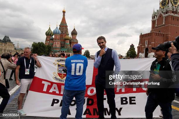 Gareth Southgate lookalike Neil Rowe poses with England fans in Red Square as he causes a stir as football fans, TV crews and tourists mistake him...