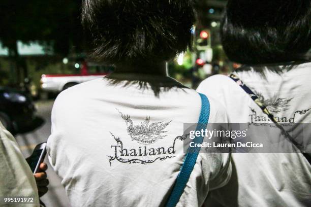 Onlookers watch and cheer as ambulances transport some of the rescued schoolboys from a helipad to Chiangrai Prachanukroh Hospital on July 10, 2018...