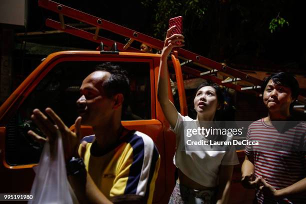 Onlookers watch and cheer as ambulances transport some of the rescued schoolboys from a helipad to Chiangrai Prachanukroh Hospital on July 10, 2018...