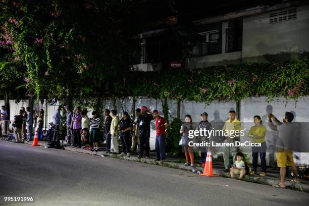 Onlookers watch and cheer as ambulances transport some of the rescued schoolboys from a helipad to Chiangrai Prachanukroh Hospital on July 10, 2018...