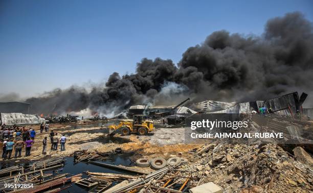 Picture taken on July 10, 2018 shows smoke plumes blowing from a blaze that broke out due to extreme summer temperatures in a warehouses near...