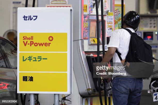 Customer returns a fuel pump nozzle after refueling a motorbike at a Showa Shell Sekiyu K.K. Gasoline station in Tokyo, Japan, on Tuesday, July 10,...