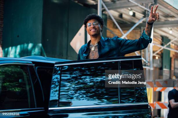 Kelly Oubre Jr throws a peace sign from his car during New York Fashion Week Mens Spring/Summer 2019 on July 9, 2018 in New York City.
