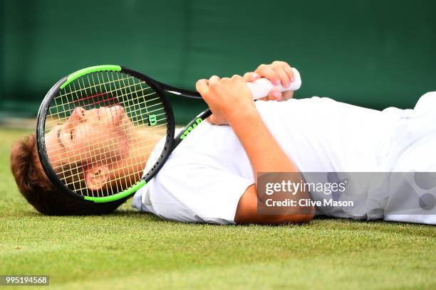 Emilio Nava of the United States lays on the court during his Boys' Singles second round match on day eight of the Wimbledon Lawn Tennis...