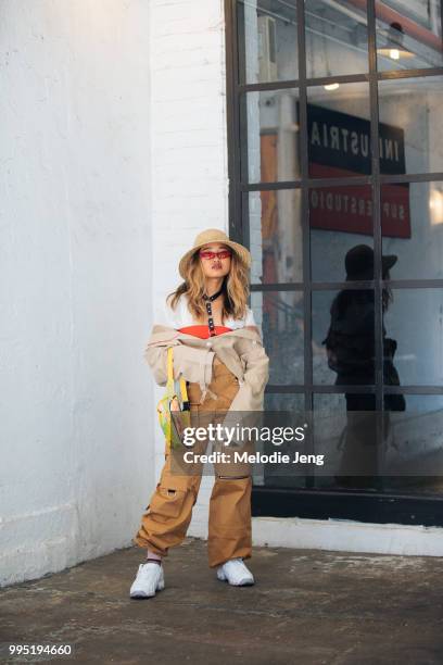 Guest in a hat and tan cargo pants during New York Fashion Week Mens Spring/Summer 2019 on July 9, 2018 in New York City.