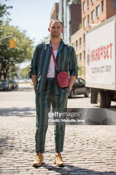 Guest in green stripe outfit and gold Nike sneakers during New York Fashion Week Mens Spring/Summer 2019 on July 9, 2018 in New York City.