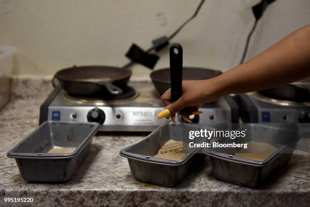 Worker breaks up sand before performing a quality control test at the Hi-Crush Partners LP mining facility in Kermit, Texas, U.S., on Wednesday, June...