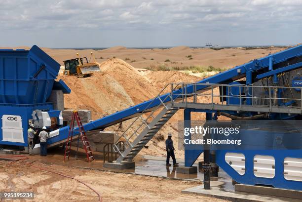 Workers operate a processing machine at the Hi-Crush Partners LP sand mining facility in Kermit, Texas, U.S., on Wednesday, June 20, 2018. In the...