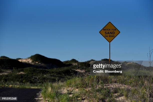 Road sign warns of sand at Monahans Sandhills State Park in Monahans, Texas, U.S., on Tuesday, June 19, 2018. In the West Texas plains, frack-sand...