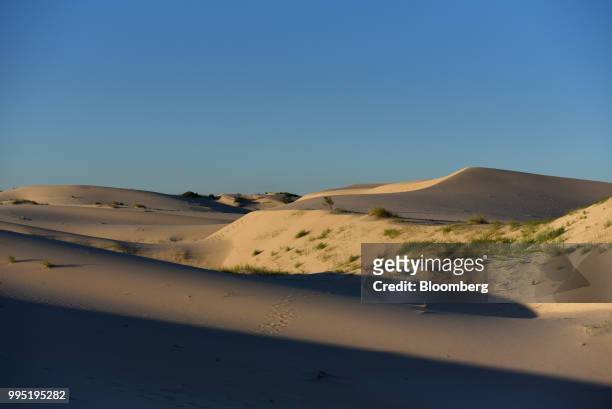 Sand dunes stand at Monahans Sandhills State Park in Monahans, Texas, U.S., on Tuesday, June 19, 2018. In the West Texas plains, frack-sand mines...