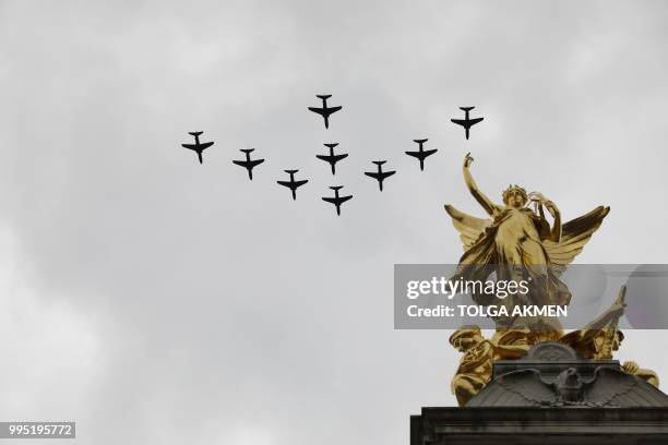 Military aircraft take part in a fly-past over the Queen Victoria Memorial on the Mall outside Buckingham Palace in London on July 10, 2018 to mark...