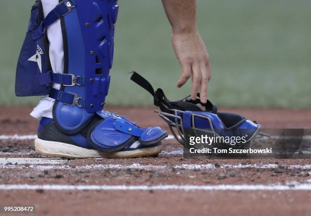 Russell Martin of the Toronto Blue Jays picks up his mask off the dirt during MLB game action against the New York Yankees at Rogers Centre on June...