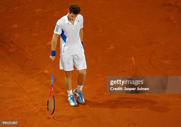 Andy Murray of Great Britain throws his racket at the end of his second set in his quarter final match against David Ferrer of Spain during the Mutua...