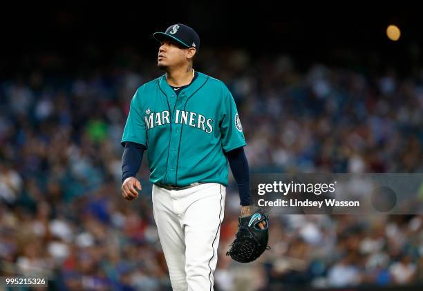 Felix Hernandez of the Seattle Mariners walks back to the dugout after pitching five innings against the Colorado Rockies, giving up eight hits and...