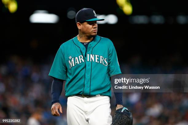 Felix Hernandez of the Seattle Mariners walks back to the dugout after pitching five innings against the Colorado Rockies, giving up eight hits and...