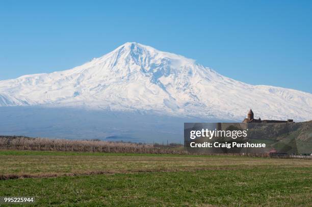 snow-covered mt ararat towers above khor virap monastery and farmland. - dormant volcano stock pictures, royalty-free photos & images