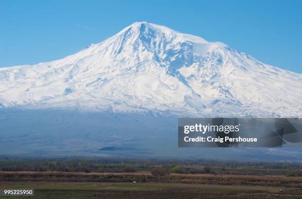 snow-covered mt ararat towers above farmland. - dormant volcano stock-fotos und bilder