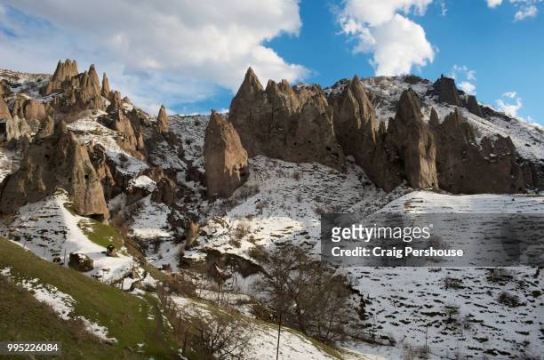 volcanic rock pinnacles on snow-covered mountain above old goris. - craig pershouse stock pictures, royalty-free photos & images
