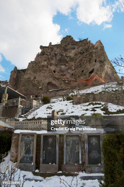 images of deceased family above graves in cemetery below volcanic rock pillar in old goris. - craig pershouse stockfoto's en -beelden