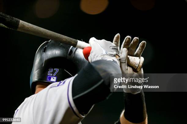 Trevor Story of the Colorado Rockies wears Nike MVP batting gloves on deck in the ninth inning against the Seattle Mariners at Safeco Field on July...
