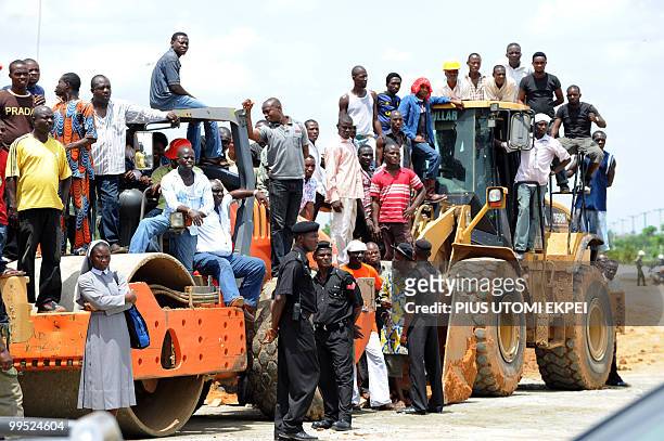 Construction workers stand on trucks as they wait for Nigerian President Goodluck Jonathan's arrival to Port Harcourt Friday, May 14, 2010. Nigerian...