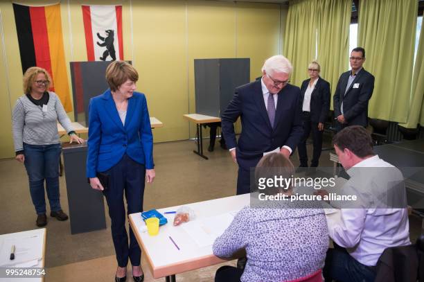 German president Frank-Walter Steinmeier and his wife Elke Buedenbender cast their votes at a polling station for the Federal Election 2017 in...