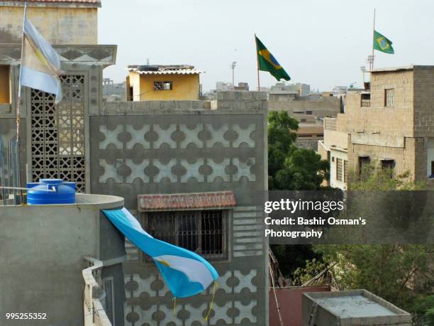 narrowed streets of lyari are painted with flags of different countries playing fifa world cup 2018 - bashir stock-fotos und bilder