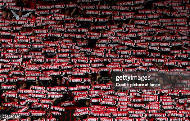 Dpatop - Nuremberg's fans hold up scarfs reading "1. FCN - Die Nummer eins in Franken" before the start of the German 2. Bundesliga match between...