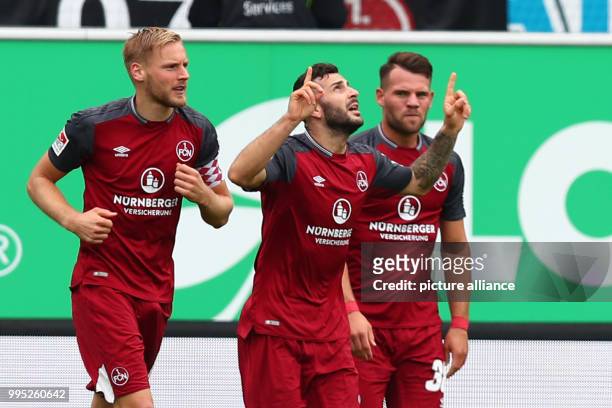 Nuremberg's Mikael Ishak cheers over his 0-1 score with team mates Hanno Behrens and Eduard Loewen during the German 2. Bundesliga match between...