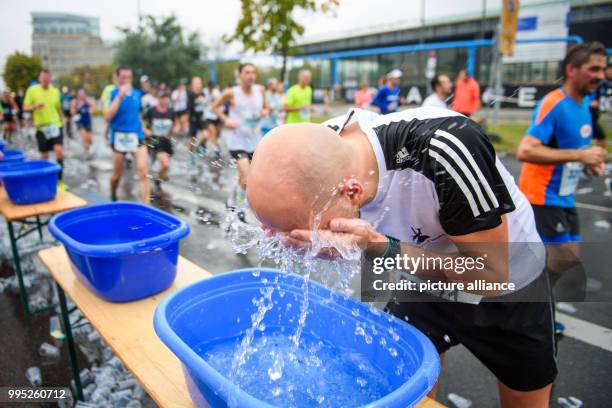 Participant of the 44th Berlin Marathon refreshes himself in Berlin, Germany, 24 September 2017. Photo: Gregor Fischer/dpa