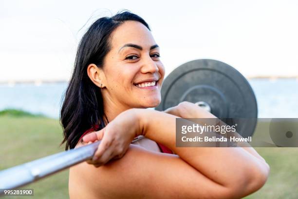 healthy, strong women by the beach exercising and lifting weights - weight lifting stock-fotos und bilder