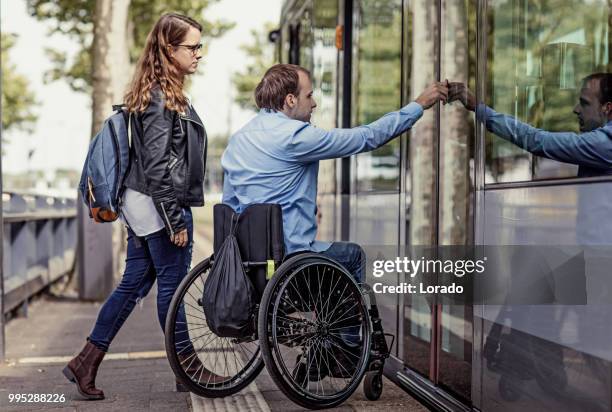 wheelchair using young man and his girlfriend travelling around a modern city - transporte público imagens e fotografias de stock