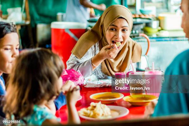 a family eating roti canai at food stall - roti canai stock pictures, royalty-free photos & images