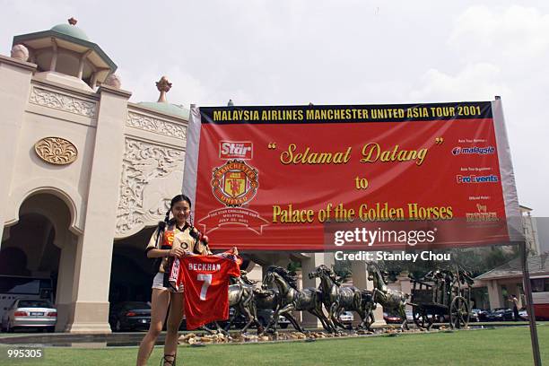 Female Manchester United fan displays the jersey of her idol David Beckham at the Palace of the Golden Horses Hotel in Kuala Lumpur, where the team...