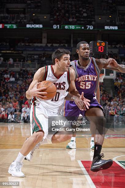 Carlos Delfino of the Milwaukee Bucks drives the ball against Earl Clark of the Phoenix Suns on April 3, 2010 at the Bradley Center in Milwaukee,...